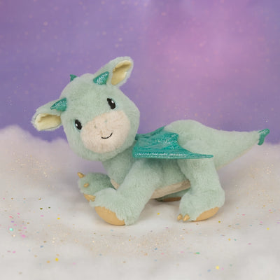 Plush dragon toy with green wings on a white and purple gradient background