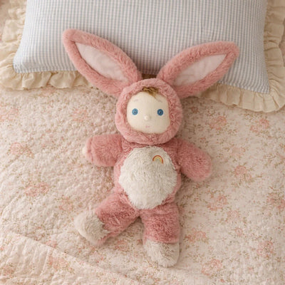 Pink plush bunny toy on a floral bedspread