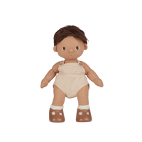 Plush baby doll with brown hair, beige romper, and brown shoes on a white background