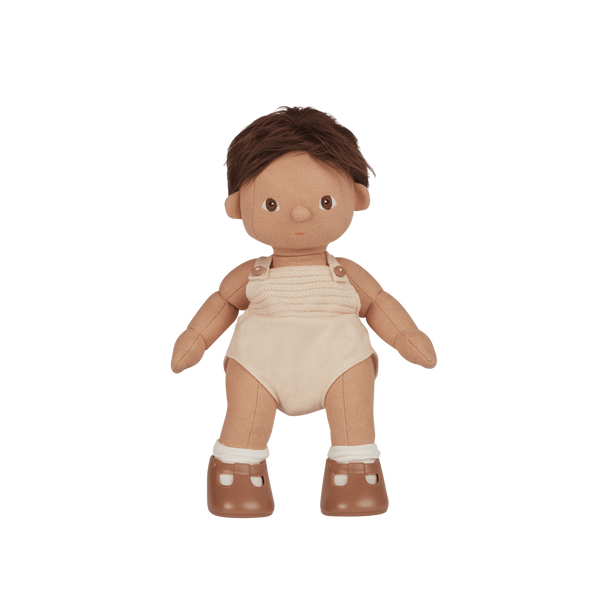 Plush baby doll with brown hair, beige romper, and brown shoes on a white background