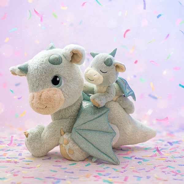 Two plush dragon toys on a pastel background with colorful sprinkles