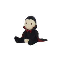 Stuffed toy with a black hood and red trim on a white background