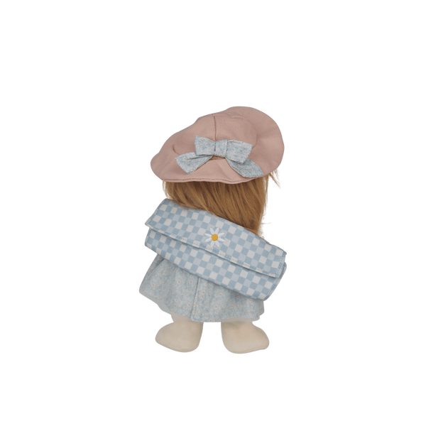 Stuffed toy with a pink hat and blue checkered dress on a black background