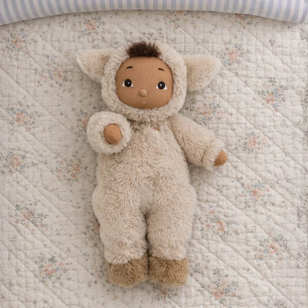 Stuffed animal toy in a fluffy outfit on a floral quilted surface