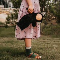 Image of a little girl holding a black cat, soft plush toy doll for kids