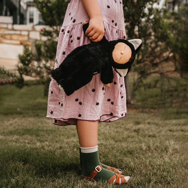 Image of a little girl holding a black cat, soft plush toy doll for kids