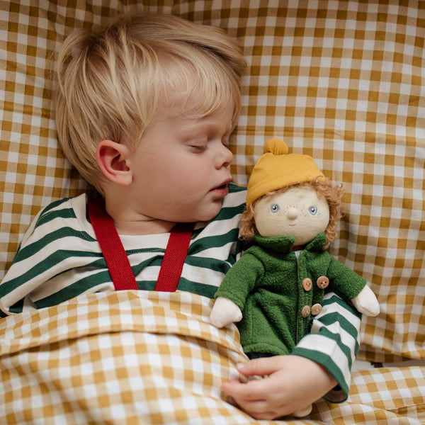 Child holding a doll with a checkered background
