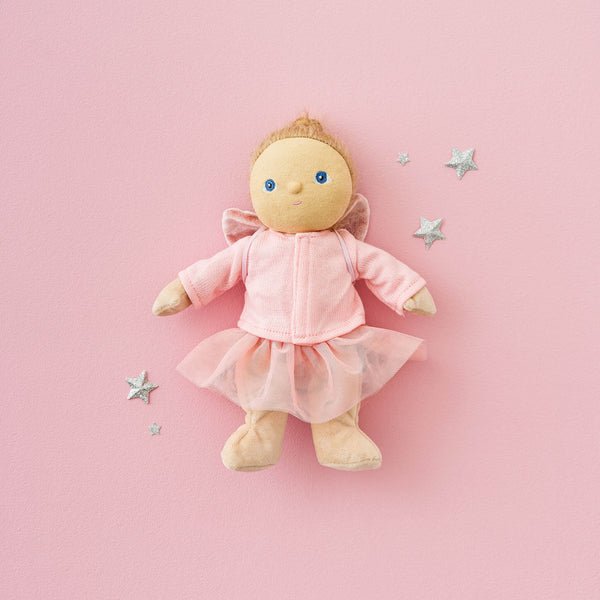 Stuffed doll in a pink outfit with stars on a pink background