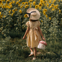Olli Ella Rattan Mushroom Basket - musk and white coloured in field of sunflowers