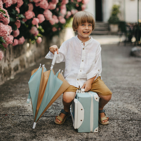 Olli Ella See Ya Umbrella pictured with suitcase and child